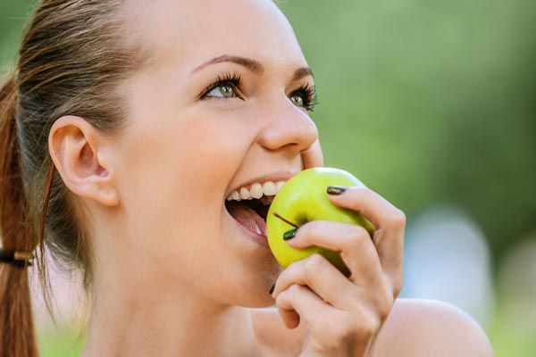 woman bites into apple